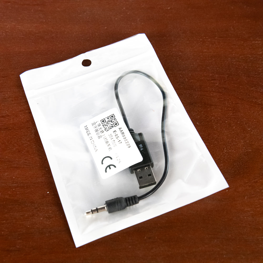 USB adapter cable on a white card with a QR code and CE logo, on a wooden surface.