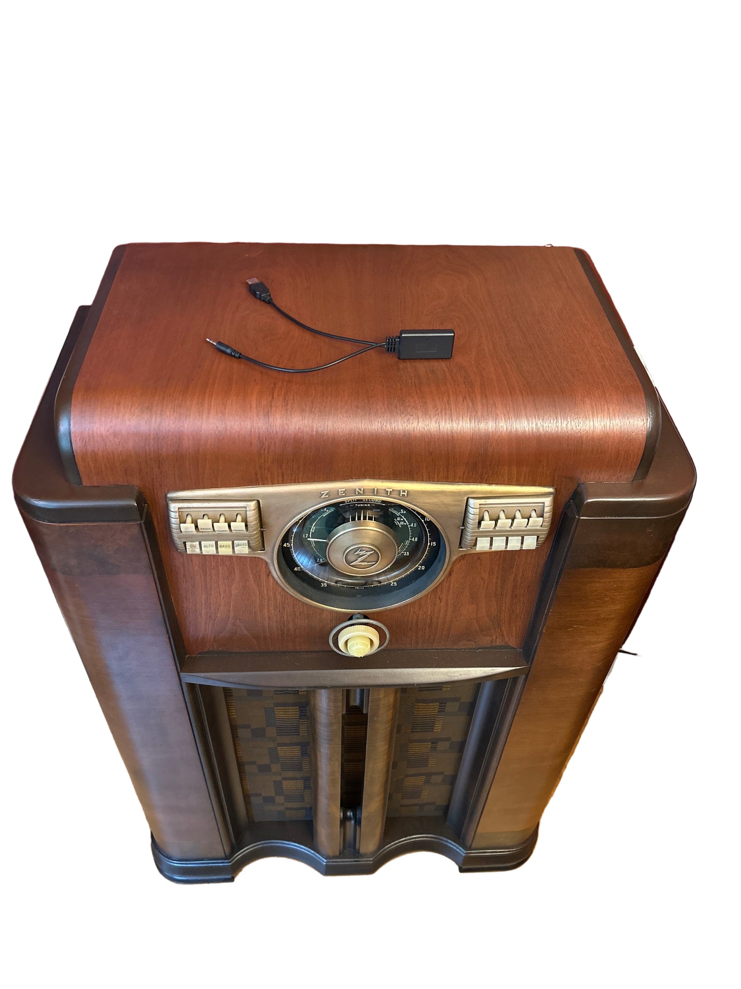 Vintage-style wooden radio on a stand against a red wall.