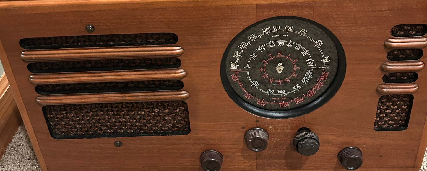 Vintage wooden radio with a circular dial and control knobs.
