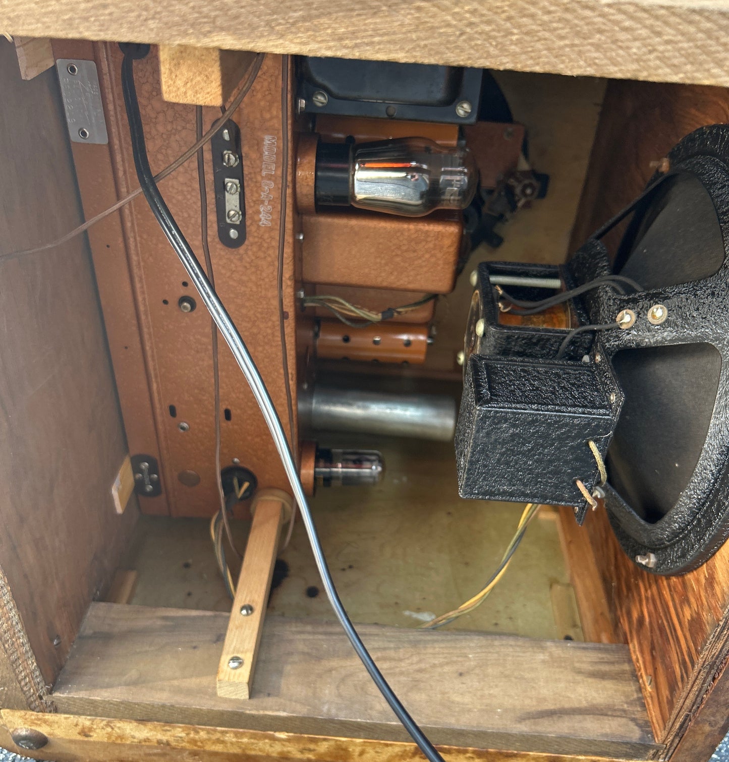Close-up of a wooden case with electronic components and tools inside.