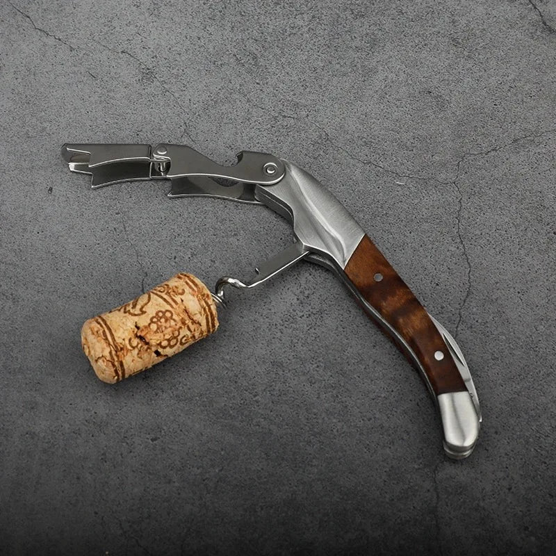 Wine opener with wooden handle and cork on a gray surface
