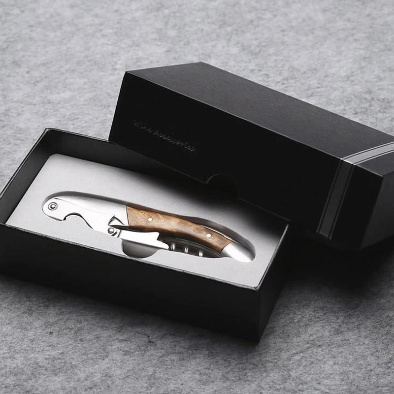 Corkscrew with wooden handle in a black box on a gray background