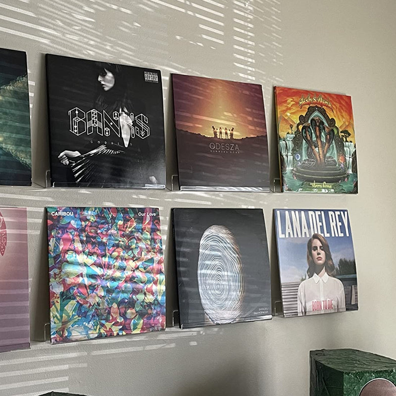Clear plastic vinyl record display shelf, designed for wall-mounted storage and showcasing LPs, 12-inch, and 7-inch records in a sleek, modern style.