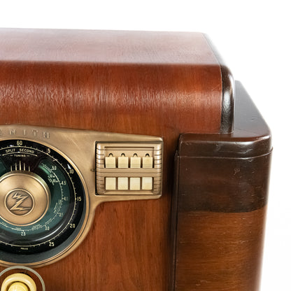 Close-up of a vintage wooden radio with brass accents on a white background