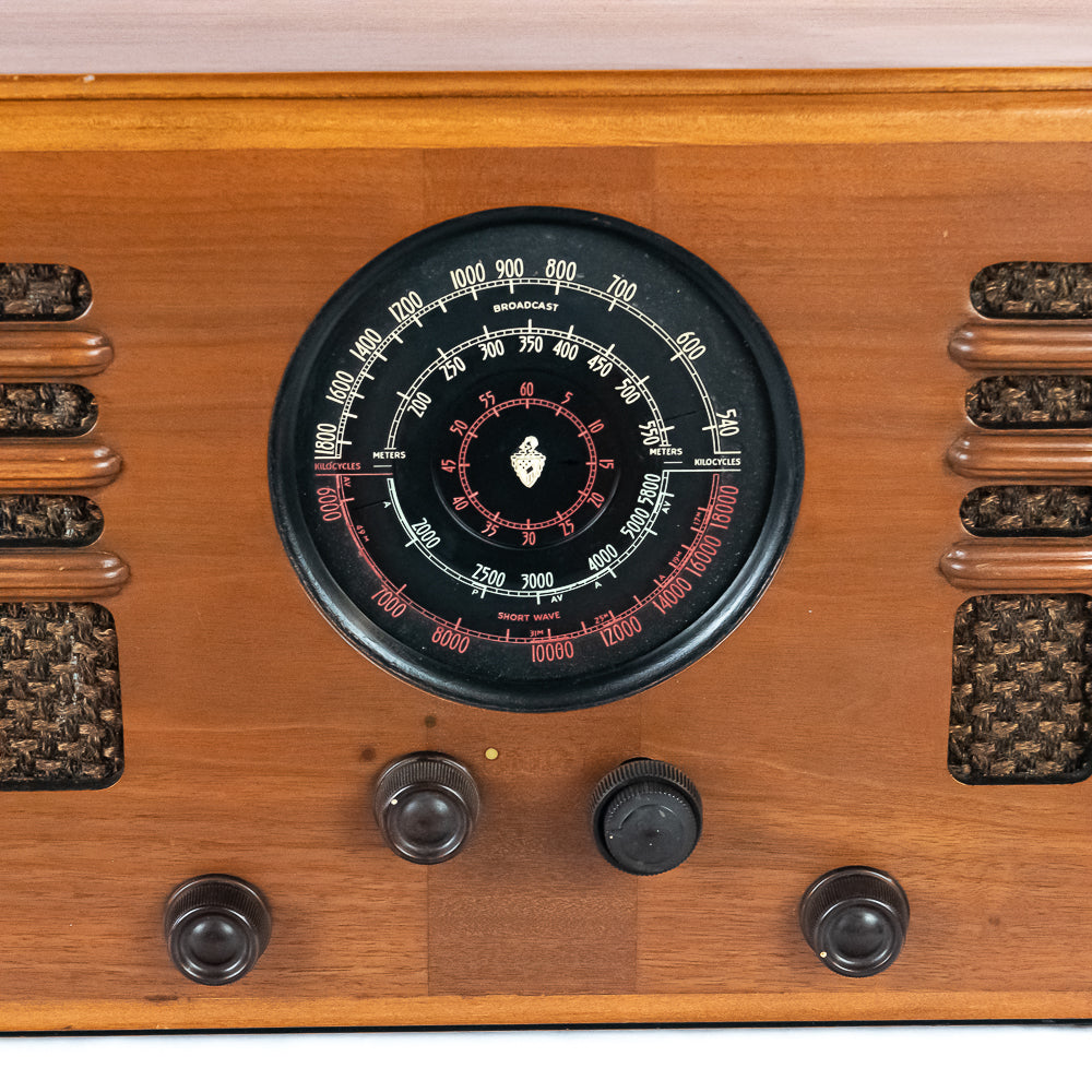 Close-up of a vintage radio with wooden casing and dial