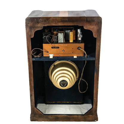 Vintage wooden radio cabinet with a round speaker and control panel on a white background