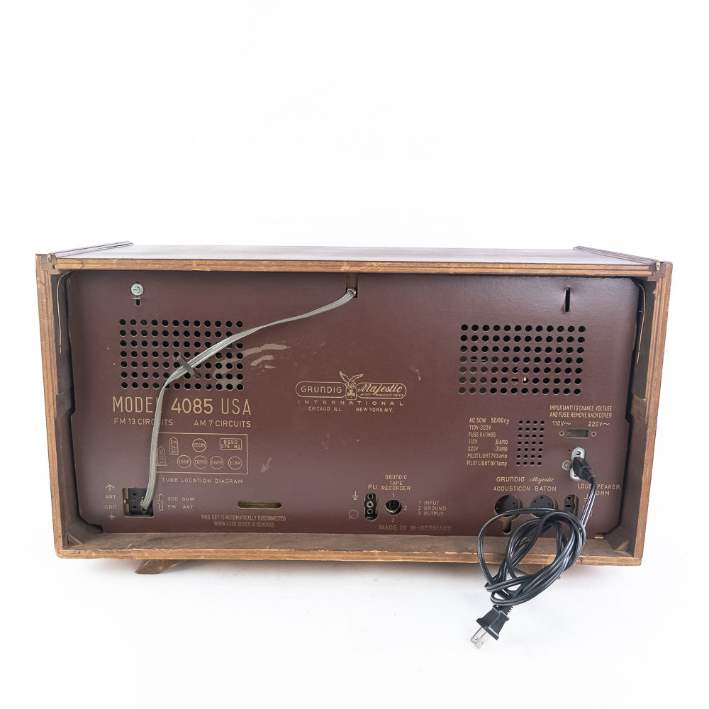 Back view of a vintage radio with 'Grundig' branding on a white background