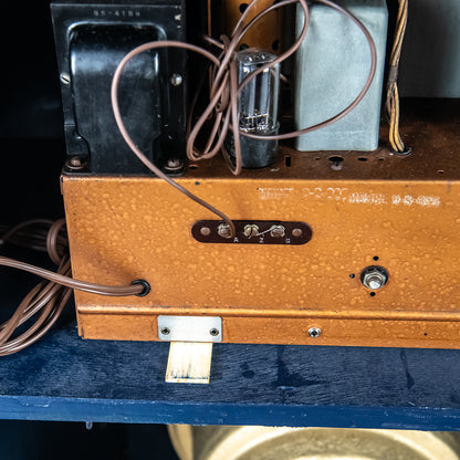 Close-up of an old electronic device with wooden casing and visible wiring.