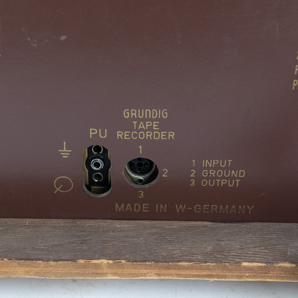 Grundig tape recorder with input, ground, and output labels on a brown background