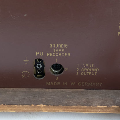 Grundig tape recorder with input, ground, and output labels on a brown background