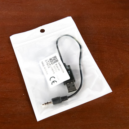 USB adapter cable on a white card with a QR code and CE logo, on a wooden surface.