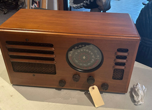 Vintage wooden radio with a tag on a table