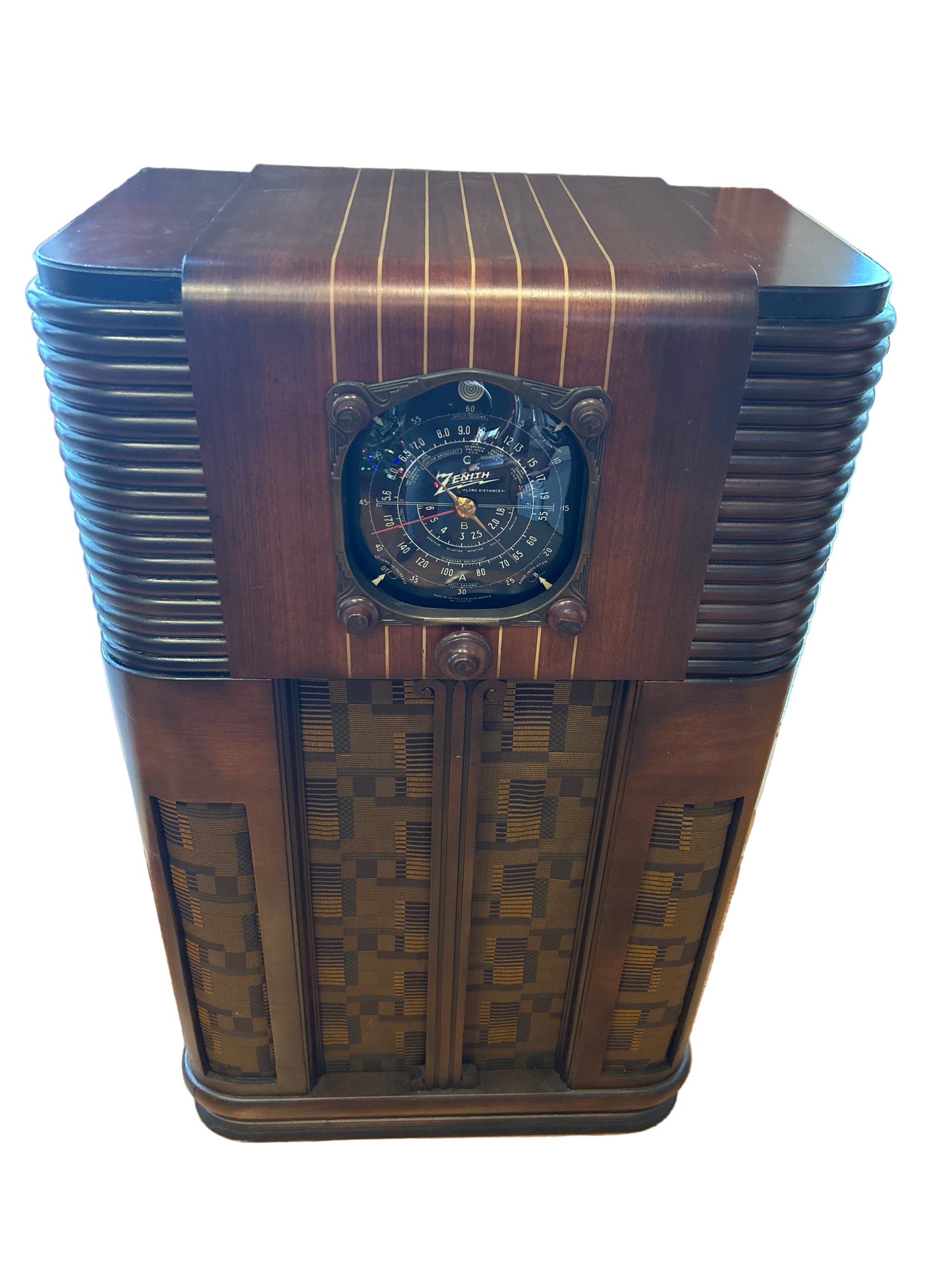 Vintage wooden radio with decorative patterns on a wooden floor.
