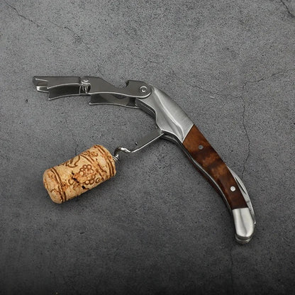 Wine opener with wooden handle and cork on a gray surface